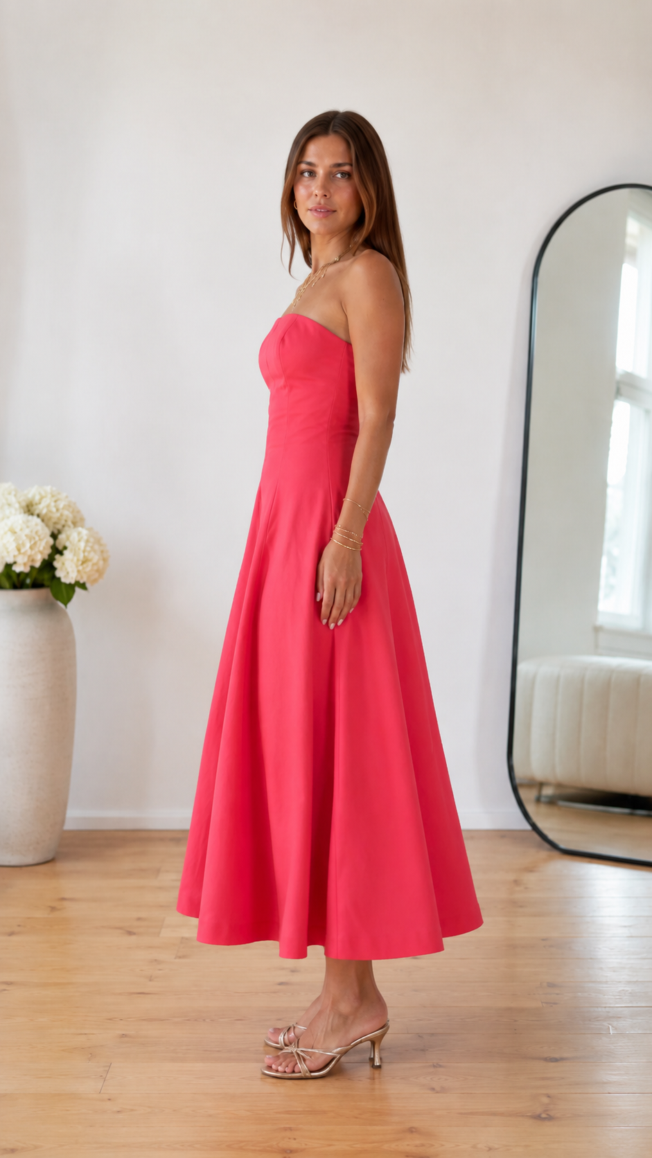 Side view of coral pink strapless fit and flare midi dress